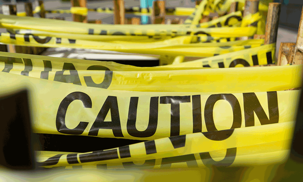 Lengths of yellow tape with CAUTION written on in black lettering are hung.